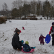 Parents play with their children in the snow near the Kotikolo family café